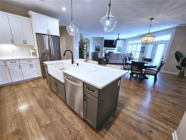 129 Bay Ct, Chartiers, PA 15301 - kitchen with a sink, stainless steel appliances, white cabinets, a ceiling fan, and hanging light fixtures