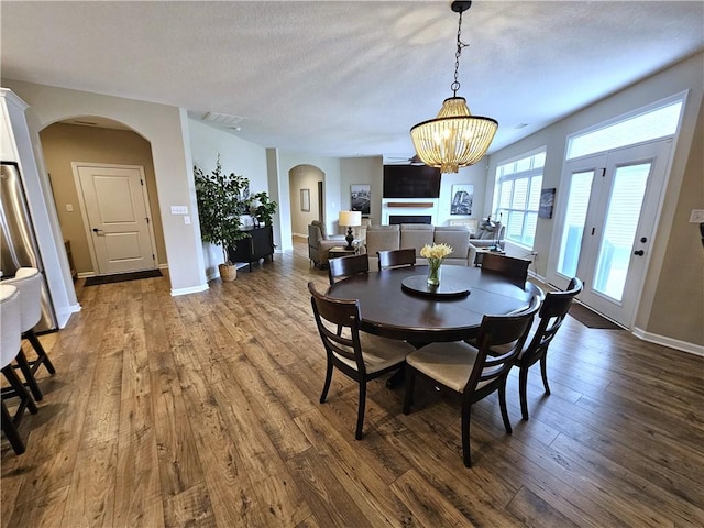 129 Bay Ct, Chartiers, PA 15301 - dining space with arched walkways, dark wood finished floors, a chandelier, baseboards, and a fireplace