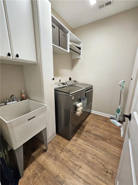 129 Bay Ct, Chartiers, PA 15301 - laundry room with washer and clothes dryer, cabinet space, light wood finished floors, and baseboards