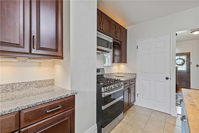 106 Haldane St, Crafton, PA 15205 - kitchen featuring appliances with stainless steel finishes, dark brown cabinetry, light tile patterned flooring, and light stone countertops