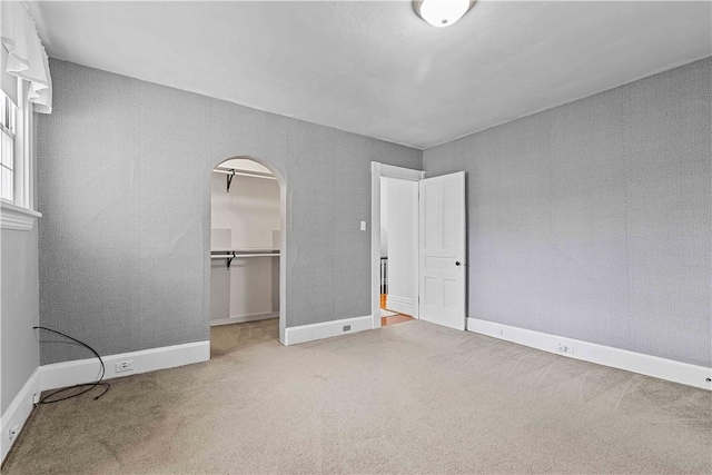 106 Haldane St, Crafton, PA 15205 - unfurnished bedroom featuring carpet flooring, arched walkways, a walk in closet, baseboards, and a closet
