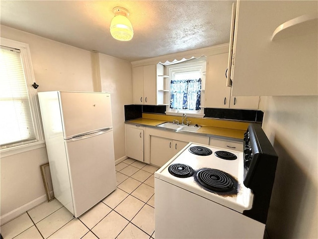 kitchen with white appliances, a sink, light tile patterned floors, white cabinets, and open shelves