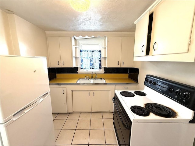 kitchen with white appliances, a sink, light tile patterned floors, a textured ceiling, and white cabinets
