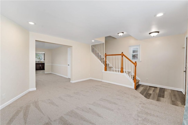 unfurnished living room with stairs, baseboards, and recessed lighting
