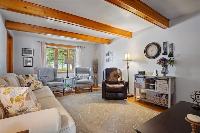living area featuring wood finished floors and beamed ceiling