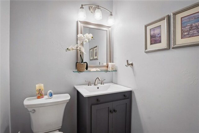 half bath featuring toilet and vanity