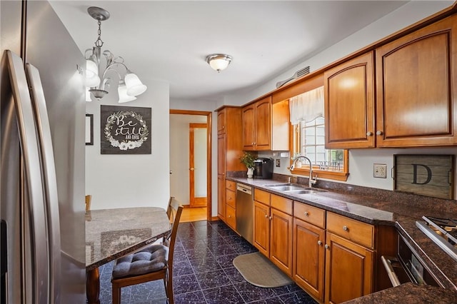 kitchen with stainless steel appliances, a sink, a chandelier, granite floors, and brown cabinetry