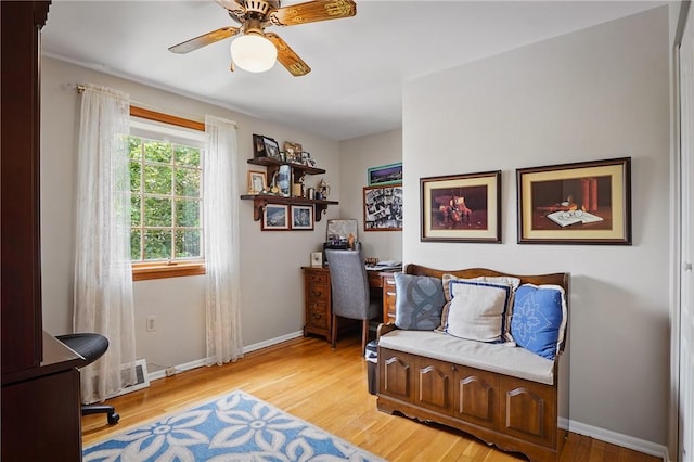 office space featuring a ceiling fan, light wood-type flooring, and baseboards