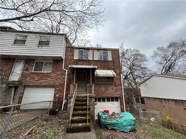 view of front facade featuring a garage, brick siding, and fence