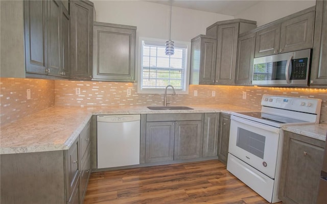 kitchen featuring white appliances, a sink, light countertops, dark wood-style flooring, and tasteful backsplash