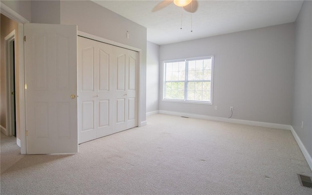 unfurnished bedroom with carpet, baseboards, a closet, and a ceiling fan