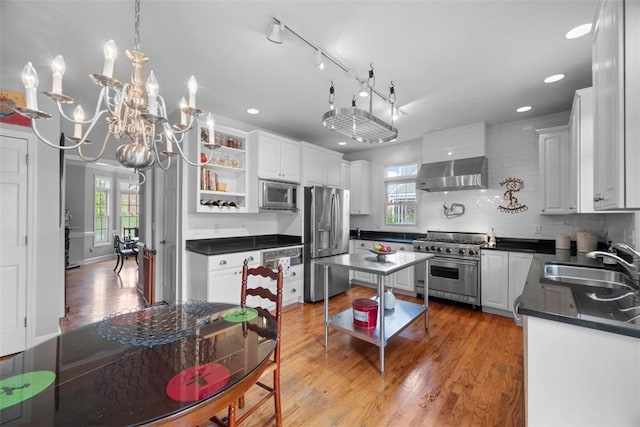 kitchen featuring appliances with stainless steel finishes, a sink, open shelves, dark countertops, and extractor fan