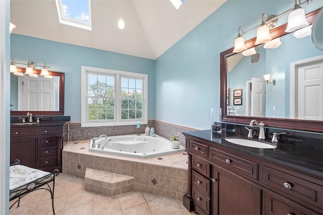 bathroom with a skylight, tile patterned flooring, a whirlpool tub, high vaulted ceiling, and two vanities