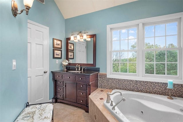 bathroom featuring vaulted ceiling, a whirlpool tub, vanity, and tile patterned floors