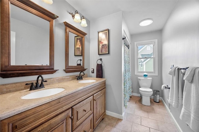 full bathroom with toilet, baseboards, and double vanity