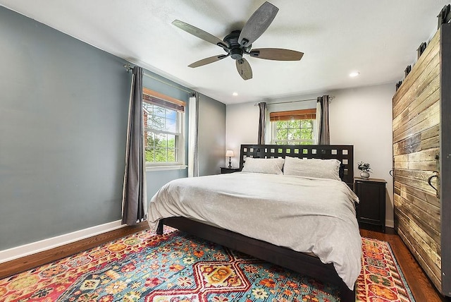 bedroom featuring dark wood-style flooring, multiple windows, baseboards, recessed lighting, and a ceiling fan
