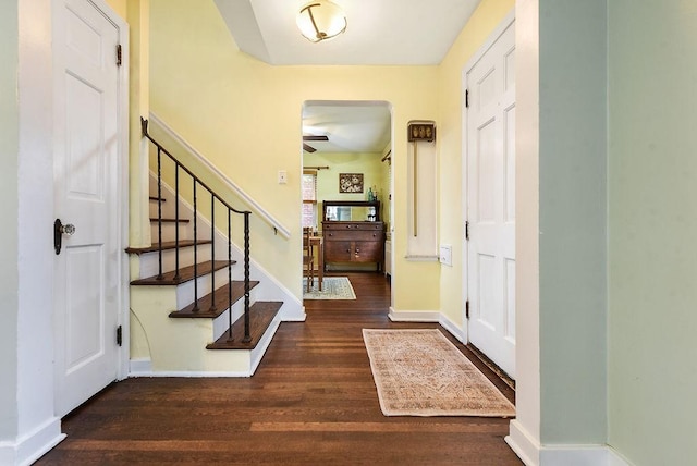 foyer entrance with wood finished floors, stairway, baseboards, and ceiling fan