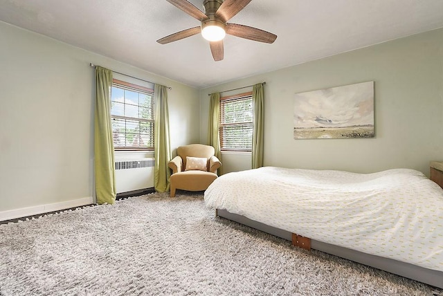bedroom with radiator, carpet, ceiling fan, and baseboards