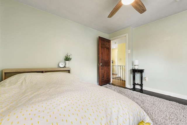 bedroom featuring wood finished floors, baseboards, and a ceiling fan