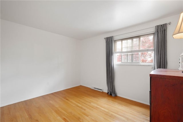 empty room with light wood-style floors and baseboards