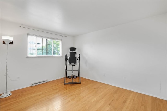workout area with light wood-style floors and baseboards
