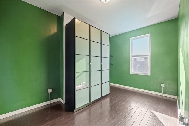 unfurnished bedroom with baseboards and wood finished floors