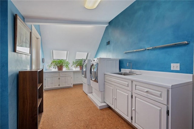 clothes washing area with cabinet space, separate washer and dryer, and bar with sink
