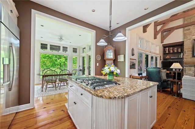 kitchen featuring stainless steel appliances, light wood-type flooring, white cabinetry, light stone counters, and recessed lighting