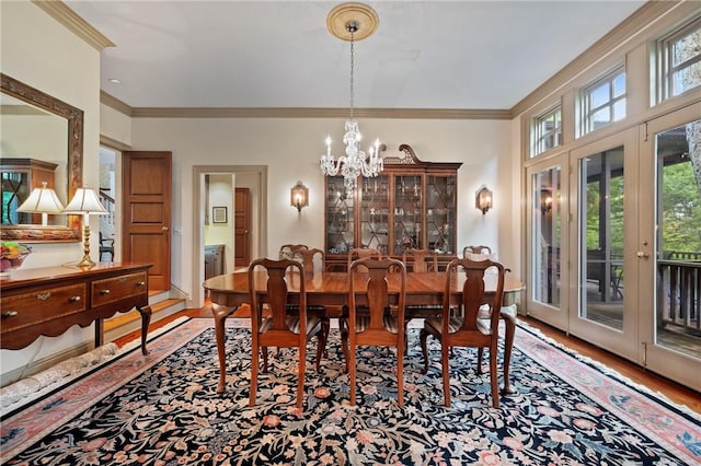 dining space featuring ornamental molding, a chandelier, and wood finished floors
