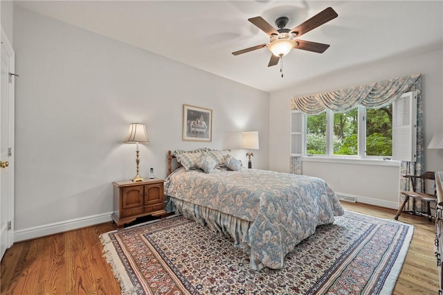 bedroom with baseboards, light wood finished floors, and ceiling fan