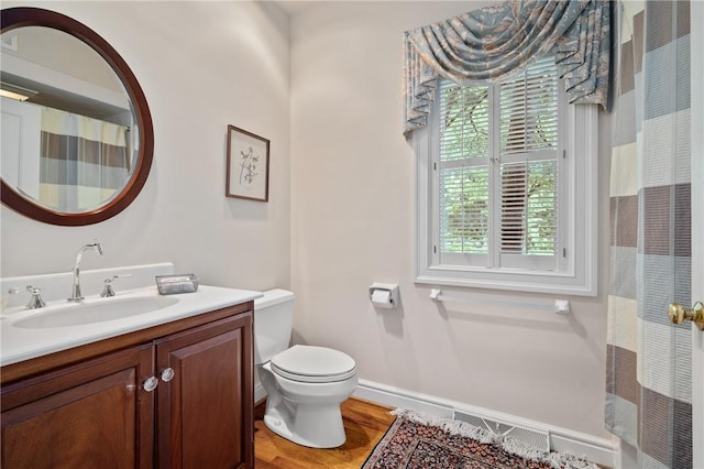 bathroom with toilet, wood finished floors, vanity, baseboards, and a shower with shower curtain