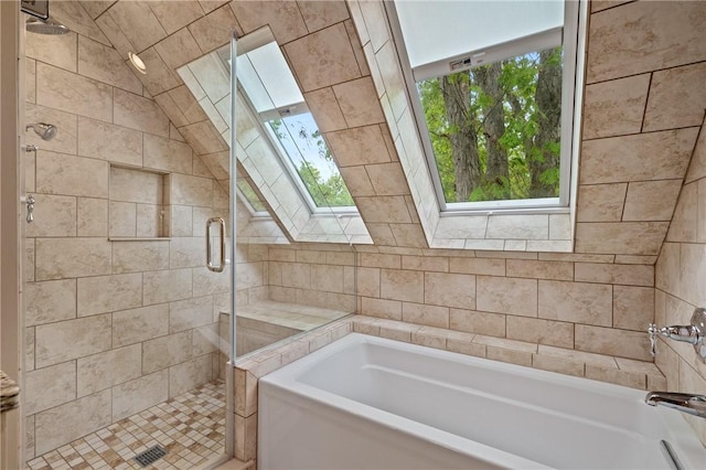 full bathroom featuring a skylight, a garden tub, a stall shower, and healthy amount of natural light