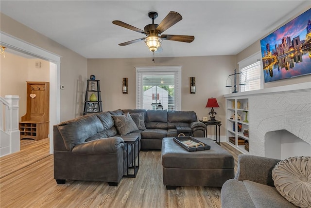 living room with light wood-type flooring, healthy amount of natural light, and ceiling fan