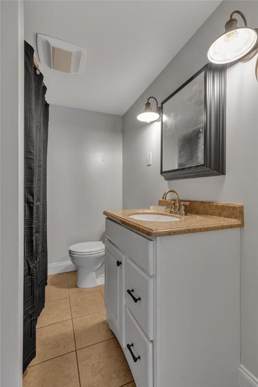 full bath featuring tile patterned floors, toilet, vanity, and baseboards