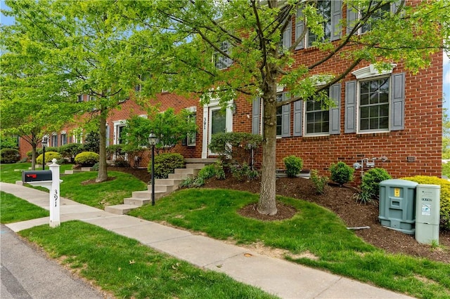 townhome / multi-family property featuring brick siding and a front lawn