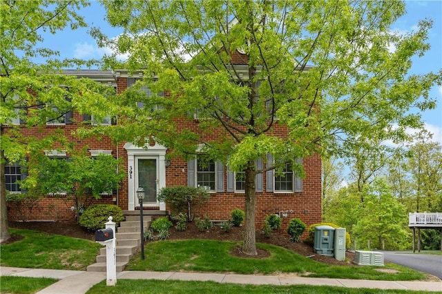 view of front of property with brick siding and a front yard