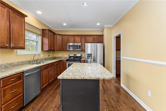kitchen with appliances with stainless steel finishes, a sink, a center island, dark wood-type flooring, and ornamental molding