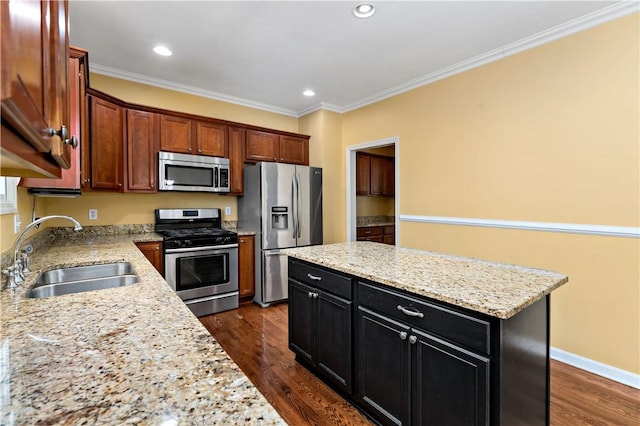 kitchen featuring stainless steel appliances, a sink, dark wood-style floors, a kitchen island, and recessed lighting