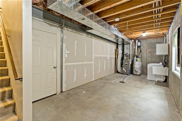 below grade area featuring water heater, washer / dryer, heating unit, and stairs