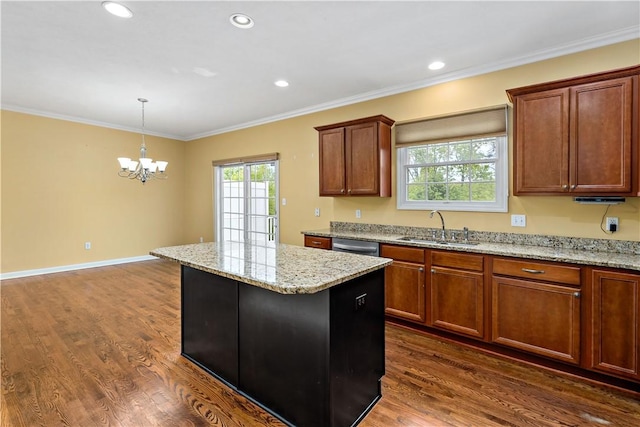 kitchen featuring a sink, a kitchen island, a chandelier, dark wood finished floors, and decorative light fixtures