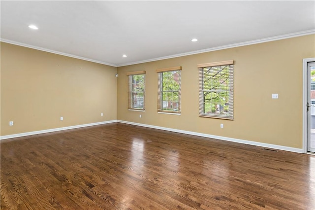 spare room featuring ornamental molding, baseboards, dark wood-type flooring, and recessed lighting