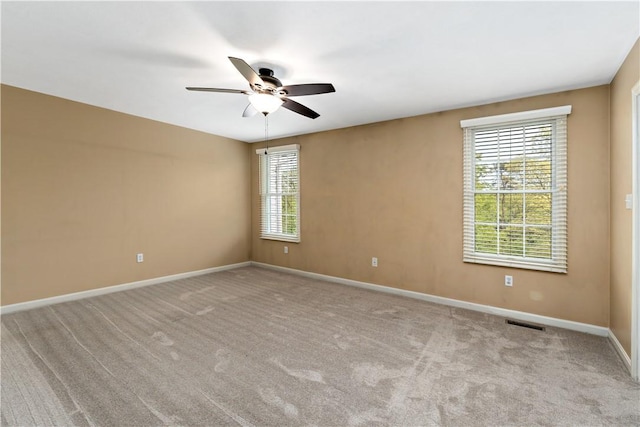 unfurnished room featuring a ceiling fan, baseboards, and carpet