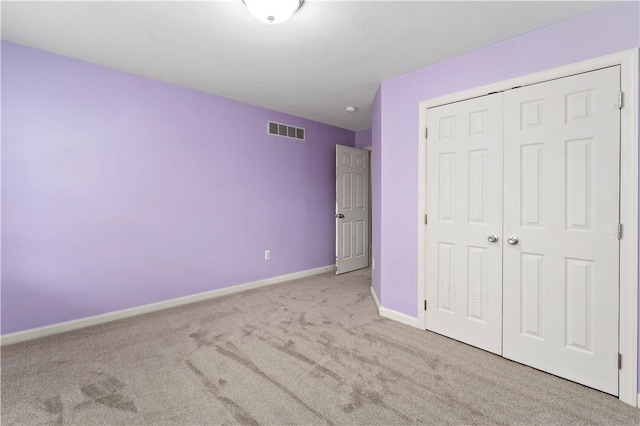 unfurnished bedroom with carpet, baseboards, and a closet