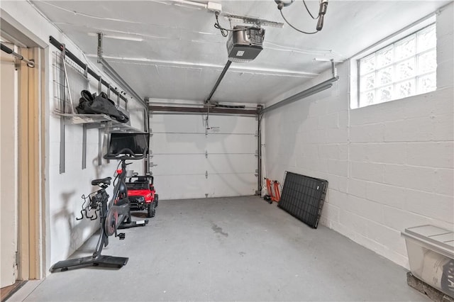 garage featuring a garage door opener and concrete block wall
