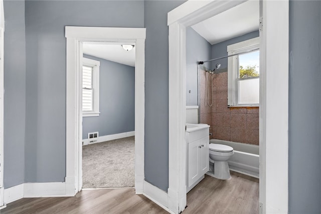 bathroom featuring plenty of natural light, wood finished floors, vanity, and bathing tub / shower combination