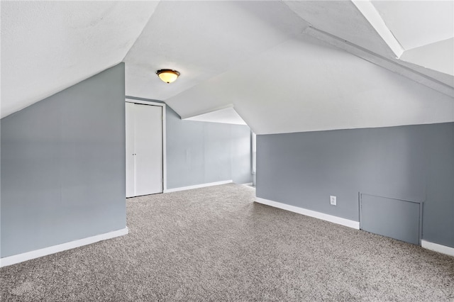bonus room featuring carpet flooring, baseboards, and lofted ceiling