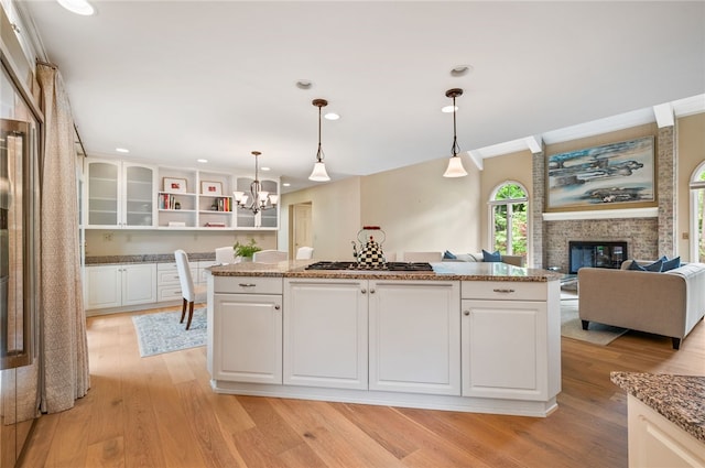 1 Way Hollow Rd, Edgeworth, PA 15143 - kitchen featuring stainless steel gas cooktop, a chandelier, open shelves, light wood-style flooring, and white cabinets