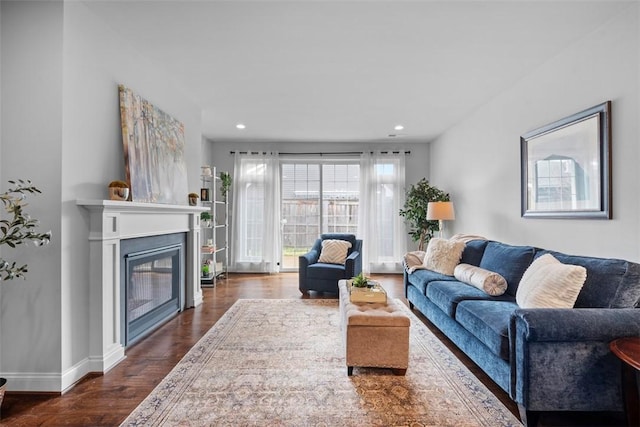 living area featuring dark wood-style flooring, a glass covered fireplace, recessed lighting, and baseboards