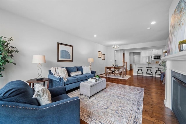 living area featuring a chandelier, dark wood-style flooring, recessed lighting, a fireplace, and baseboards