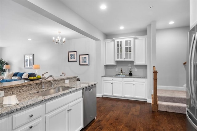 kitchen with appliances with stainless steel finishes, a sink, light stone counters, white cabinets, and dark wood-style floors